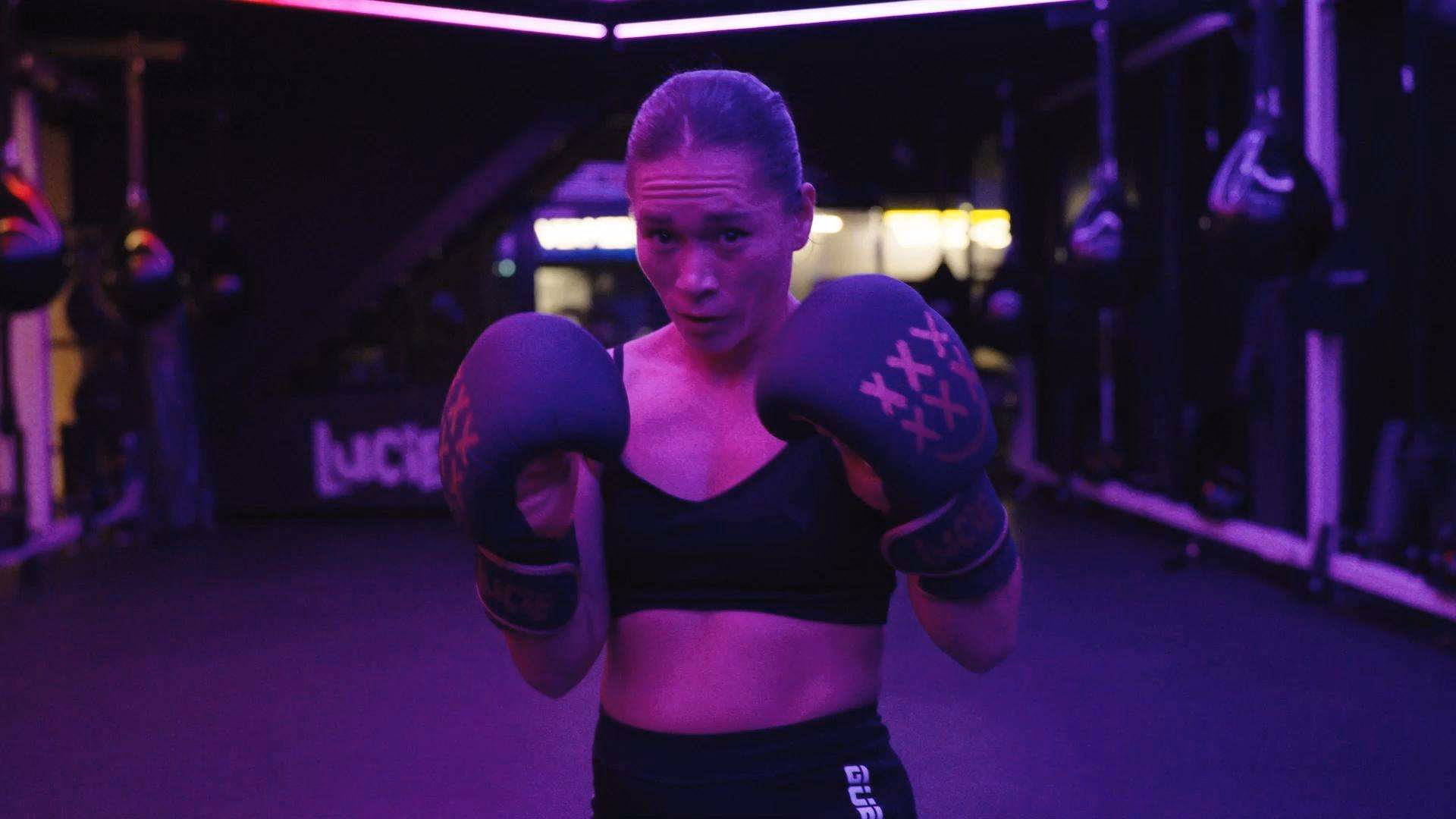 Sporter met bokshandschoenen in de LED-verlichte LUCIE gym